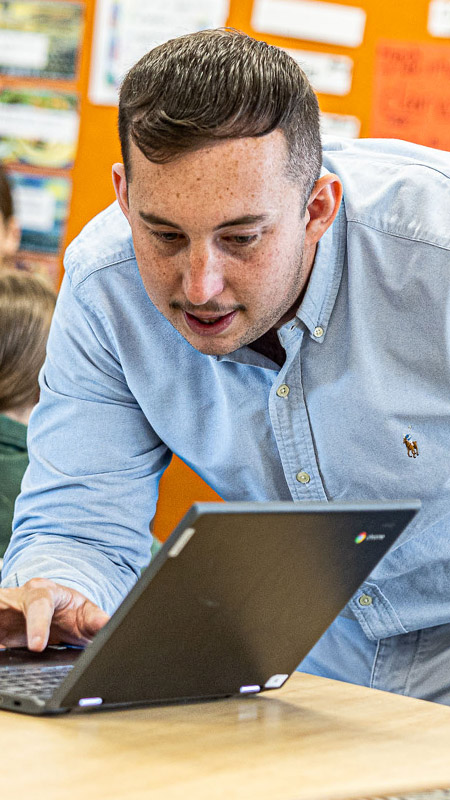 Teacher helping students at Our Lady of the Way Catholic Primary Emu Plains